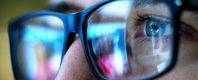 close-up of a person's eyes through black eyeglasses